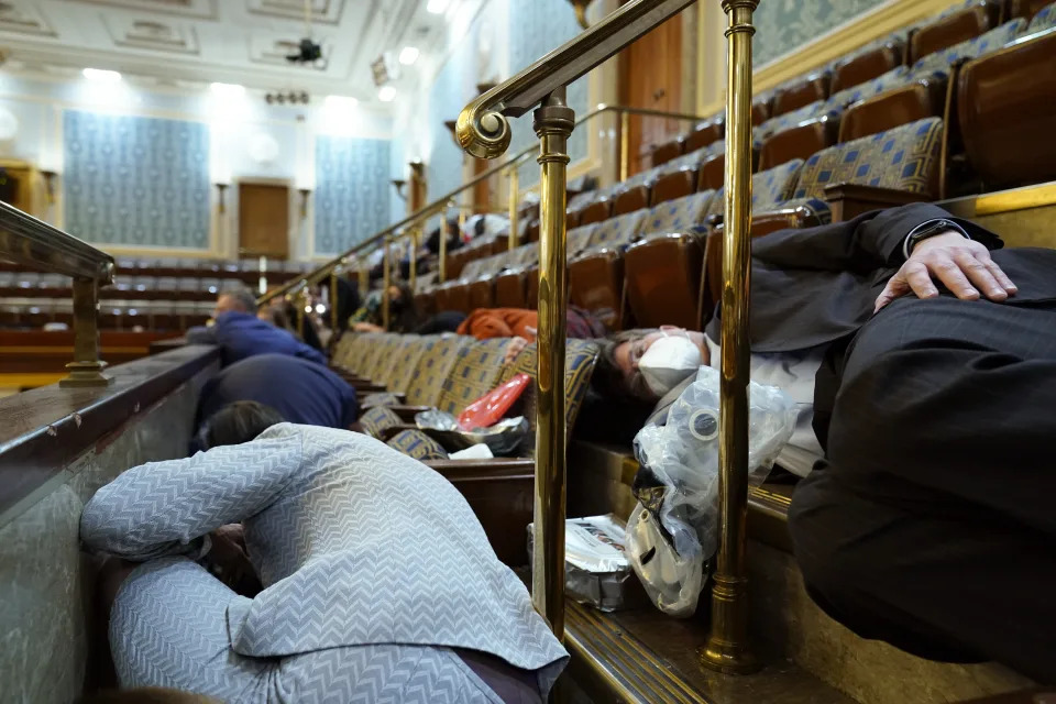 FILE - People shelter in the House gallery as rioters try to break into the House Chamber at the U.S. Capitol on Jan. 6, 2021, in Washington. (AP Photo/Andrew Harnik, File)