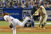 San Diego Padres' Austin Hedges, right, hits a solo home run as Los Angeles Dodgers starting pitcher Dustin May, left, and catcher Will Smith, second from left, watch along with home plate umpire John Libka during the fifth inning of a baseball game Monday, Aug. 10, 2020, in Los Angeles. (AP Photo/Mark J. Terrill)