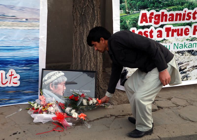 An Afghan man puts a wreath of flowers for Japanese doctor Tetsu Nakamura, who was killed in Jalalabad in yesterday's attack, in Kabul