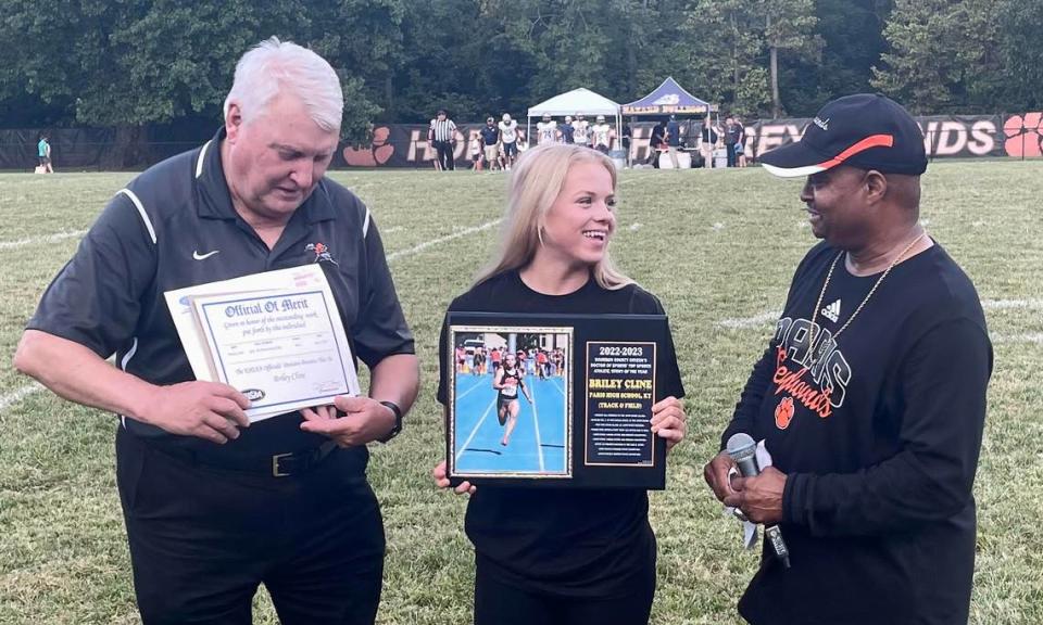 Ivan K. Rice, right, presented his annual “Doctor of Sports” Bourbon County Citizen top sports athlete award to Paris track standout Briley Cline center, as Paris athletic director Cary Barr held another honor for her ahead of Paris High School’s football game against Hazard.