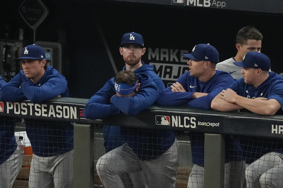 Los Dodgers de Los Ángeles observan el noveno inning del juego en que los Bravos de Atlanta los eliminaron en la Serie de Campeonato de la Liga Nacional, el sábado 23 de octubre de 2021 (AP Foto/John Bazemore)