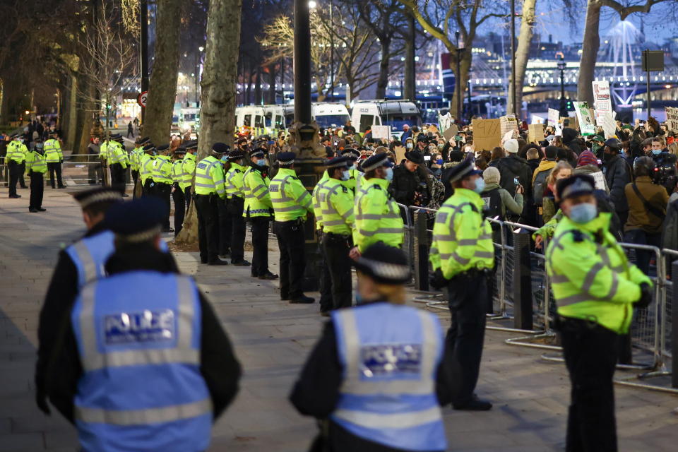 Police officers stand guard outside New Scotland Yard during the protest.