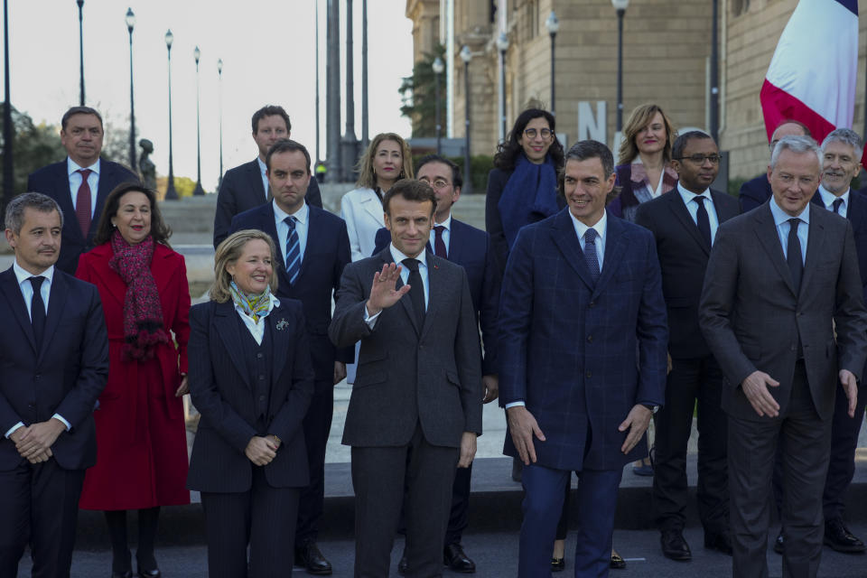 French President Emmanuel Macron waves to reporters, during a family photo with Spanish counterpart Pedro Sánchez and members of France and Spanish delegations in Barcelona, Spain, on Thursday, Jan. 19, 2023. A summit between the Spanish and French governments, led by their executive leaders, prime minister Pedro Sánchez and president Emmanuel Macron, is held in the capital of Catalonia to strengthen relations between the European neighbors by signing a friendship treaty. (AP Photo/Emilio Morenatti)