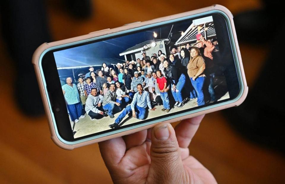 A photo on a phone shows family gathered around Elvira Madrigal, seated in wheelchair, center, who just celebrated her 107th birthday. Photographed Tuesday, May 7, 2024 at Elvira’s home in Fresno.