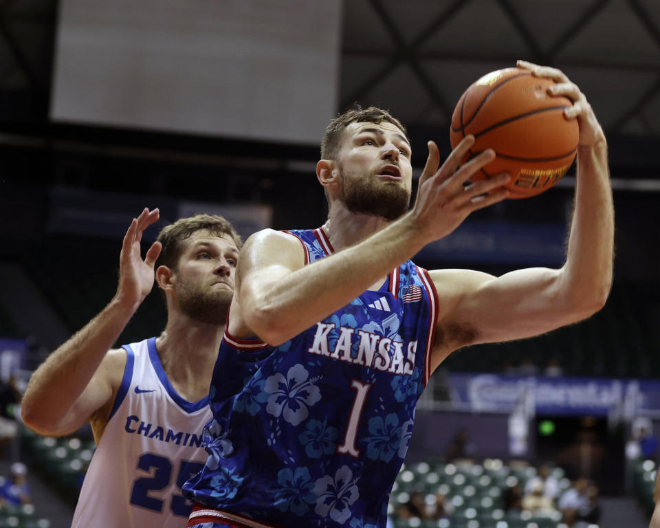 Kansas center Hunter Dickinson (1) goes for the net over Chaminade forward Wyatt Lowell (25) during the second half of an NCAA college basketball game, Monday, Nov. 20, 2023, in Honolulu. (AP Photo/Marco Garcia)