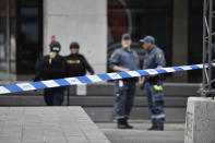 A police officer in a gas mask attends the scene after a truck crashed into a department store injuring several people in central Stockholm, Sweden, Friday April 7, 2017. (Noella Gow TT News Agency via AP)