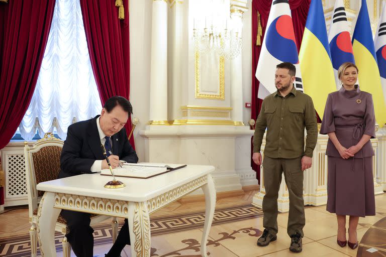 El presidente surcoreano, Yoon Suk Yeol, firma el libro de visitas a la presidencia ucraniana junto a Zelensky