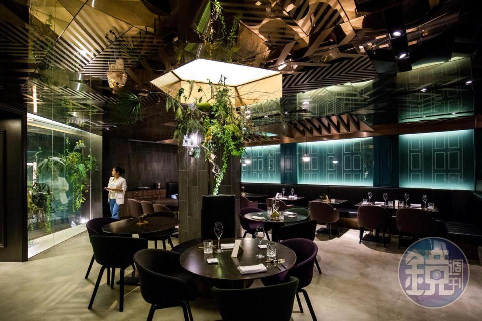位在地下室的餐廳空間以綠色植栽、玻璃和金屬材質創造現代休閒的氛圍。