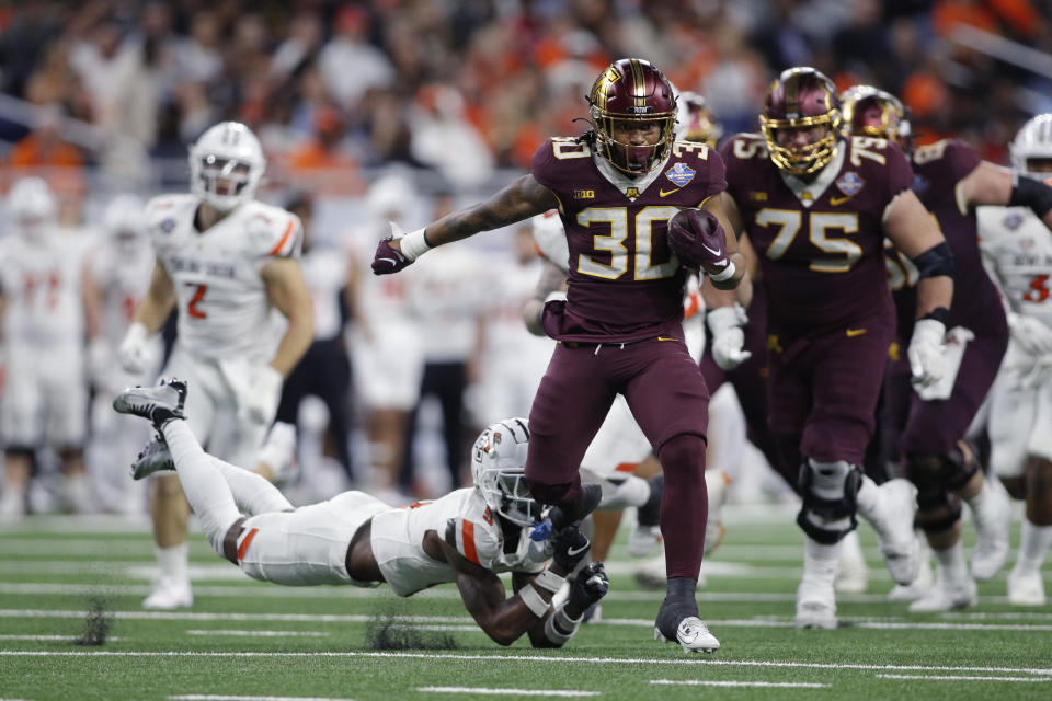 Minnesota running back Jordan Nubin (30) escapes a tackle attempt by Bowling Green safety Darius Lorfils, left, during the second half of the Quick Lane Bowl NCAA college football game, Tuesday, Dec. 26, 2023, in Detroit. (AP Photo/Al Goldis)
