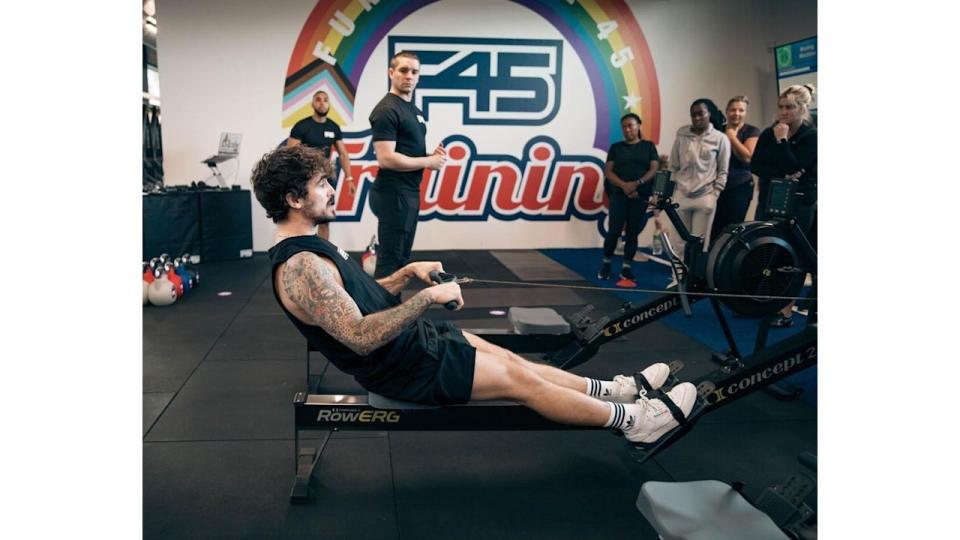 A f45 fitness coach demonstrates how to use the rowing machine 