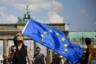 A woman holds a European flag as she attends a demonstration in Berlin, Germany, Sunday, May 19, 2019. People across Europe attend demonstrations under the slogan 'A Europe for All - Your Voice Against Nationalism'. (AP Photo/Markus Schreiber)
