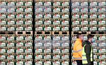 Workers walk past crates of beer on the yard of Plzensky Prazdroj brewery in Plzen