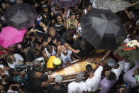 Relatives and friends of Douglas Rafael da Silva Pereira react around his coffin during his burial in Rio de Janeiro, Brazil, Thursday, April 24, 2014. A protest followed the burial of Douglas Pereira, whose shooting death sparked clashes Tuesday night between police and residents of the Pavao-Pavaozinho slum. (AP Photo/Felipe Dana)