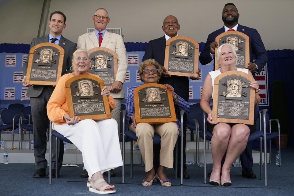 Clockwise from top left, Josh Rawitch, president of the National Baseball Hall of Fame and Museum, holding the plaque of inductee Bud Fowler, inductee Jim Kaat, inductee Tony Oliva, inductee David Ortiz, Sharon Rice-Minoso, holding the plaque of her husband and inductee Minnie Minoso, Dr. Angela Terry, holding the plaque of her uncle and inductee John Jordan O'Neil, and Irene Hodges, holding the plaque of her father and inductee Gil Hodges, pose for a photo at the conclusion of the National Baseball Hall of Fame induction ceremony, Sunday, July 24, 2022, at the Clark Sports Center in Cooperstown, N.Y. (AP Photo/John Minchillo)