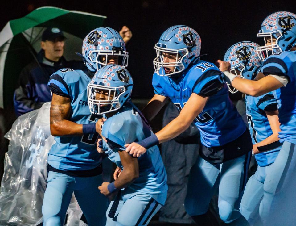 Central Valley's Deniro Simpson is surrounded by cheering teammates after he takes a Laurel Highlands blocked field goal back for a touchdown to end the 2nd quarter of their WPIAL playoff game Friday at Central Valley High School. [Lucy Schaly/For BCT]