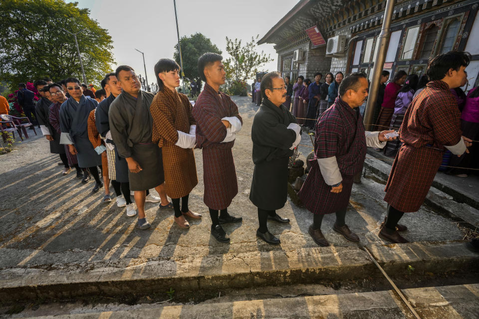 Bhutanese people in traditional attire queue up to cast their votes in the national elections in Deothang, Bhutan, Tuesday, Jan. 9, 2024. The landlocked country in the eastern Himalayan mountain range is electing a new Parliament, with the parties in contest promising to fix the nation’s economic crisis. (AP Photo/Anupam Nath)