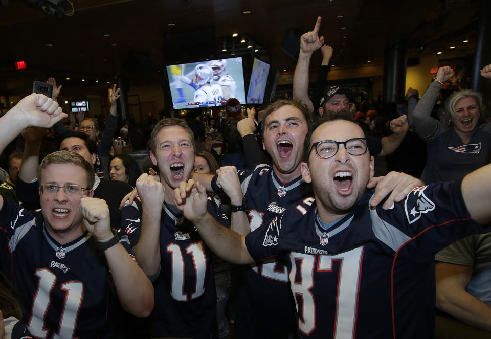 FILE - In this Feb. 3, 2019, file photo, New England Patriots cheer while watching the second half of the NFL Super Bowl 53 football game in Atlanta between the Patriots and the Los Angeles Rams at a bar in Boston. Let's get this straight from the outset: If the NFL has no fans at any games this season _ or doesn't have much of a season at all _ it will not go out of business. Sure, the 32 teams and the league itself will lose millions, very possibly billions of dollars. Its broadcast partners will take a hit harder than any that Von Miller has delivered on the field. Same for sponsors and advertisers who pinpoint pro football as the best way to reach fans (read: consumers). (AP Photo/Steven Senne, File)