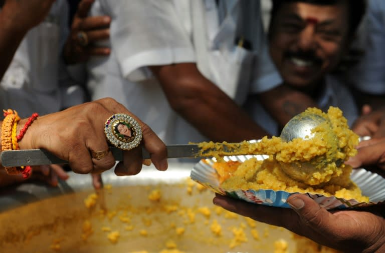 An Indian member of the All India Anna Dravida Mennetra Kazhgam (AIADMK) wears a ring bearing the image of Tamil Nadu Chief Minister Jayalalithaa Jayaram as he serves free meals in October 2016