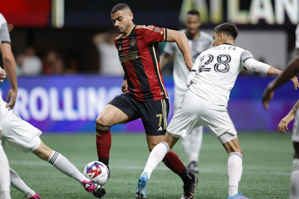 Atlanta United forward Giorgos Giakoumakis, left, drives past Toronto FC defender Raoul Petretta, right during the second half of an MLS soccer match, Saturday, March 4, 2023, in Atlanta. (AP Photo/Alex Slitz)