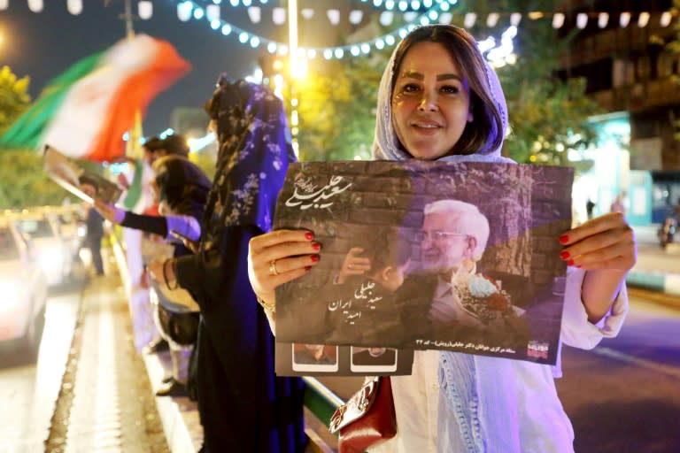 Una partidaria del candidato presidencial Said Jalili sostiene su retrato durante un mitin frente a la Universidad de Teherán, el 26 de junio de 2024 (RAHEB HOMAVANDI)