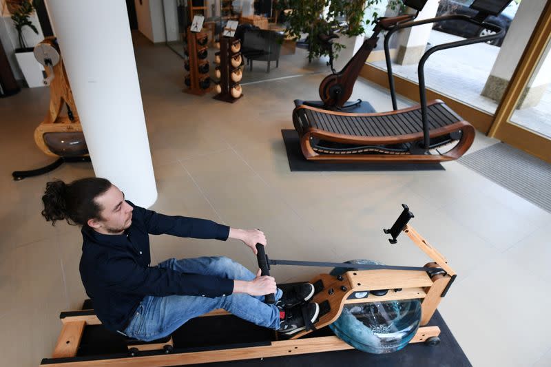 A man tries out a rowing machine in a showroom of U.S. gym equipment manufacturer WaterRower in Munich