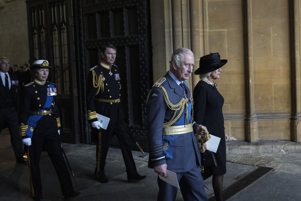 El rey Carlos III de Gran Bretaña (segundo desde la derecha), la reina consorte Camilla (derecha) y la princesa Ana (izquierda) caminan después de presentar sus respetos ante el cuerpo de la reina Isabel II en el Salón Westminster en Londres, el 14 de septiembre de 2022. (AP Foto/Emilio Morenatti)