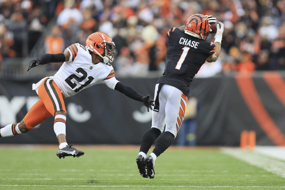 Cincinnati Bengals' Ja'Marr Chase (1) makes a catch against Cleveland Browns' Denzel Ward (21) during the second half of an NFL football game, Sunday, Dec. 11, 2022, in Cincinnati. (AP Photo/Aaron Doster)