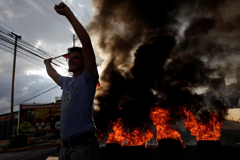 A demonstrator holds up his arms during a protest against the government of president Juan Orlando Hernandez in Tegucigalpa