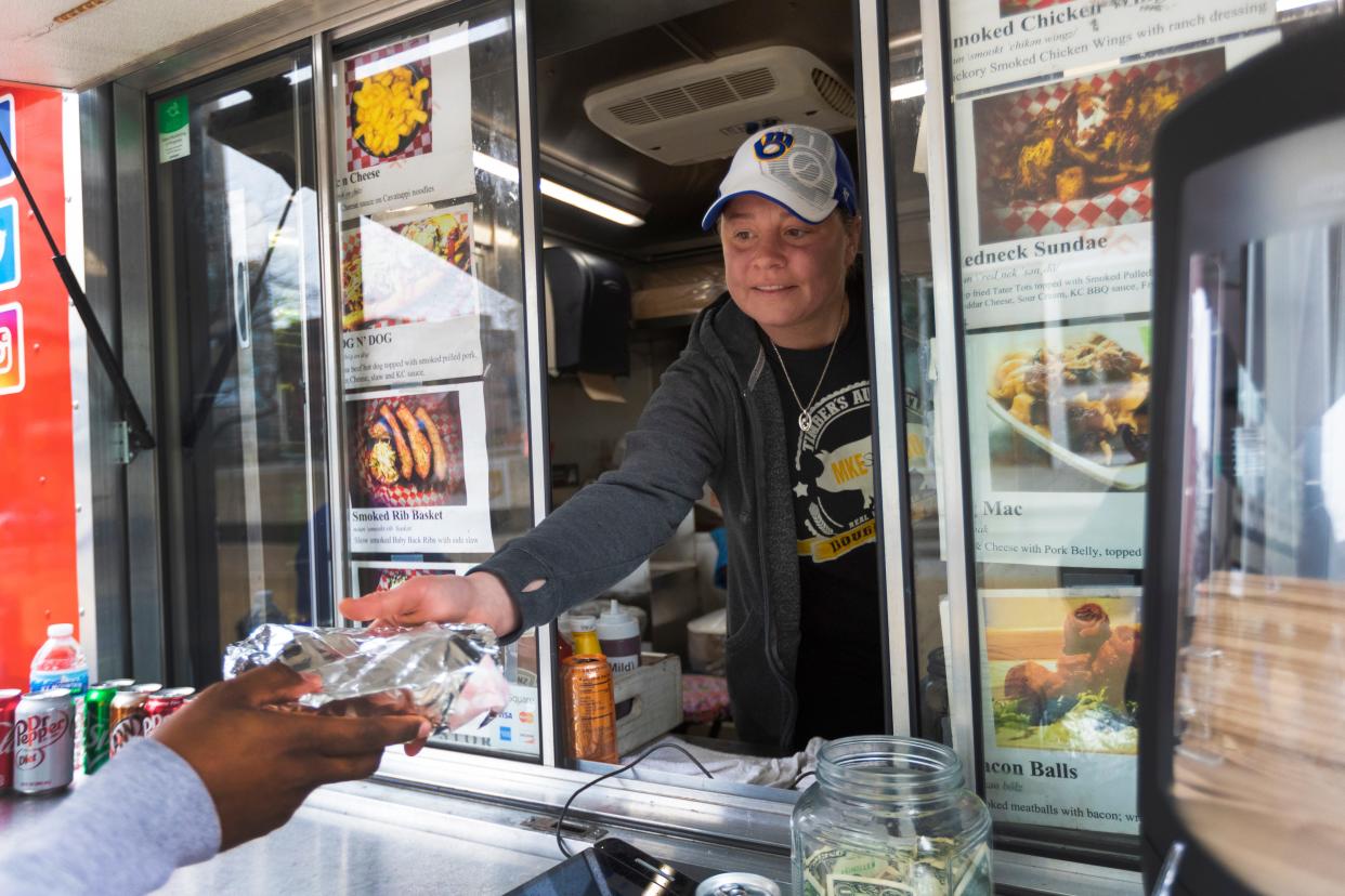 Sharon Eberhardt serves a customer from Double B's BBQ food truck on March 18, 2020, on the corner of East Wisconsin Avenue and North Van Buren Street.
