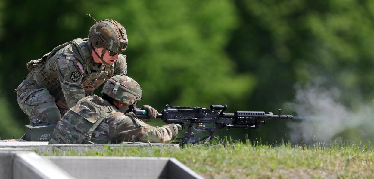 Command Sgt. Maj. William Workley, bottom, fires the first shots Tuesday, May 7, 2024, on the new machine gun range with an M240B with help from his assistant gunner, Sgt. 1st Class Kirk Deiters, top, at Camp James A. Garfield Joint Military Training Center.