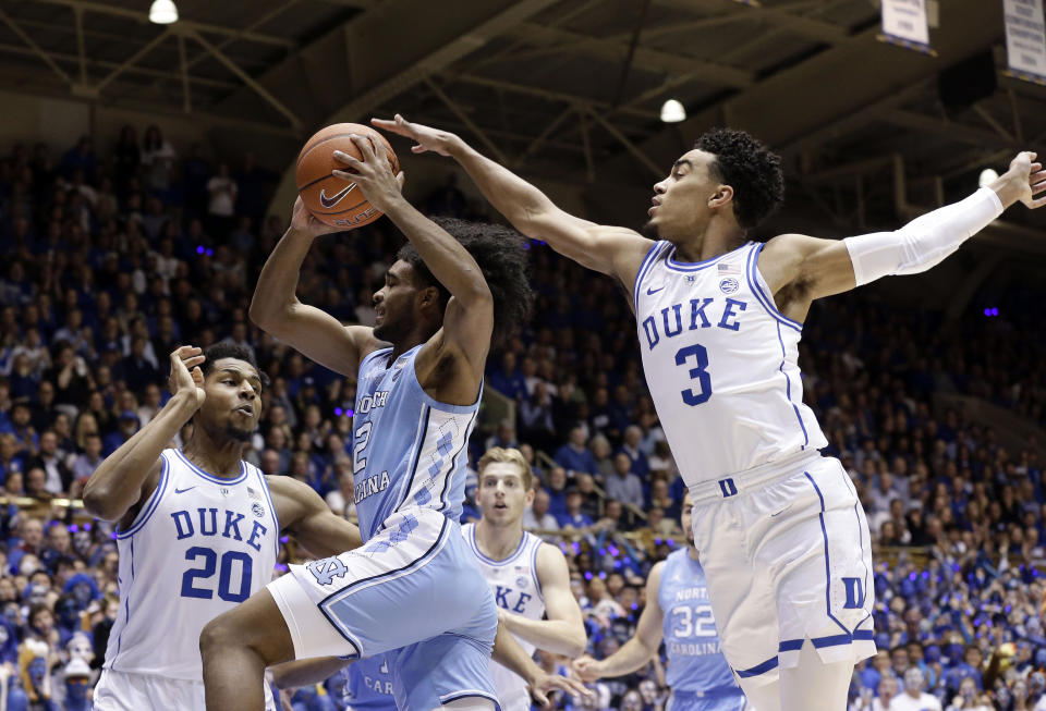 Duke's Marques Bolden (20) and Tre Jones (3) guard North Carolina's Coby White (2) during the first half of an NCAA college basketball game in Durham, N.C., Wednesday, Feb. 20, 2019. (AP Photo/Gerry Broome)