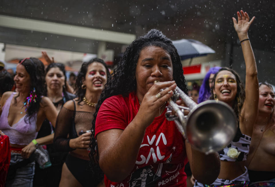 A reveler plays a horn instrument during the "Broco Burocra" or "bureaucracy" street block party in Sao Paulo, Brazil, Saturday, Feb. 11, 2023. Merrymakers are taking to the streets for the open-air block parties, leading up to Carnival's official Feb. 17th opening. (AP Photo/Tuane Fernandes)