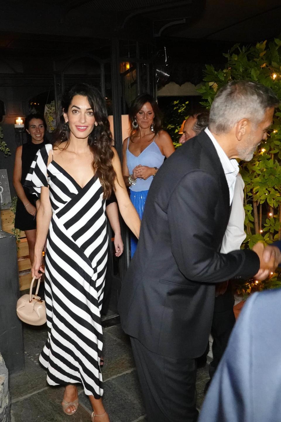 <p>WHO: Amal Clooney</p> <p>WHAT: Michelle Mason dress, Gabriela Hearst bag</p> <p>WHERE: Il Gatto Nero, Cernobbio, Italy</p> <p>WHEN: August 3, 2018</p>