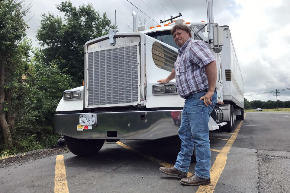 In this June 13, 2019 photo, truck driver Terry Button poses with his truck during at stop in Opal, Va., Thursday, June 13, 2019. The Trump administration has moved a step closer to relaxing federal regulations governing the amount of time truck drivers can spend behind the wheel. (AP Photo/Tom Sampson)