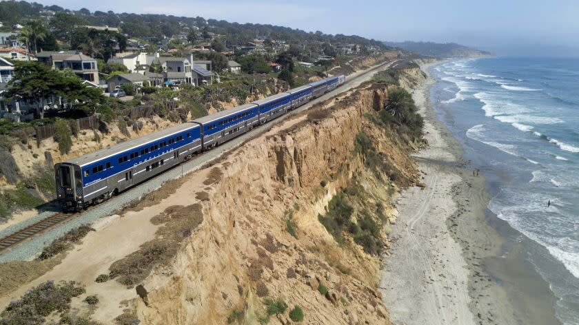 John Gibbins  San Diego Union-Tribune AN AMTRAK Surfliner train travels along the eroding sandstone cliffs in Del Mar. Protecting the busy bluff-top route will cost millions.