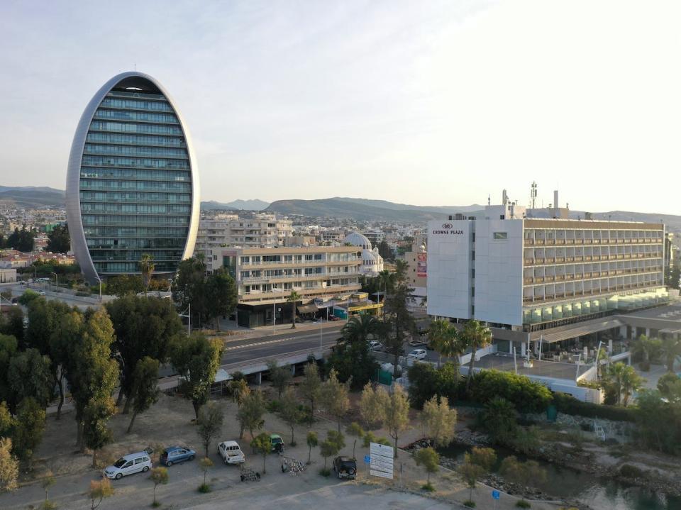 Sunrise illuminates the Oval office complex on the left and the Crowne Plaza Limassol Hotel on the right, in Limassol. Cyprus.