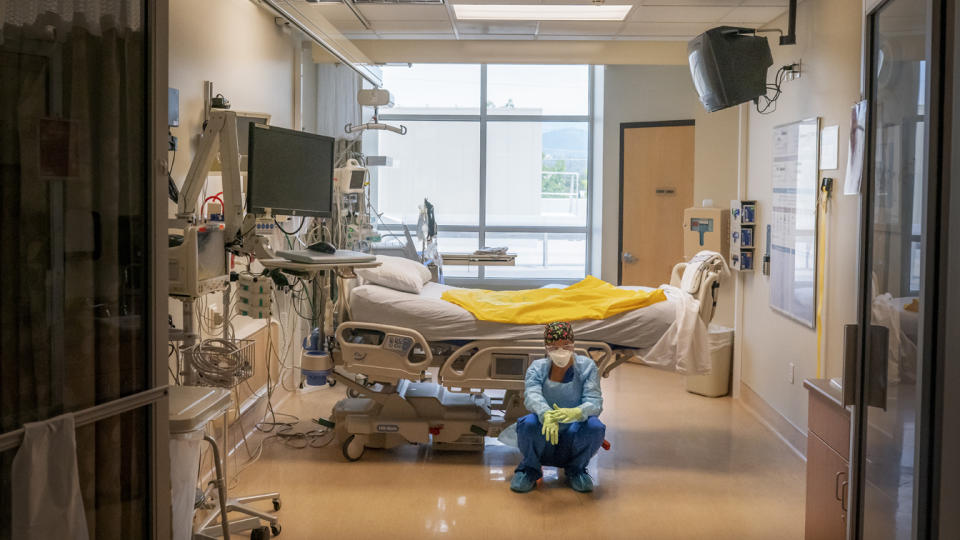 Soon after a deceased patient was removed from this ICU room at Three Rivers Asante Medical Center in Grants Pass, Ore., a nurse waits for her next COVID-19 case to be brought from the emergency room on Sept. 9.