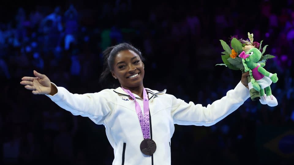 Simone Biles of the U.S. celebrates during the medal ceremony after winning the floor exercise at the women's apparatus finals. - Yves Herman/Reuters