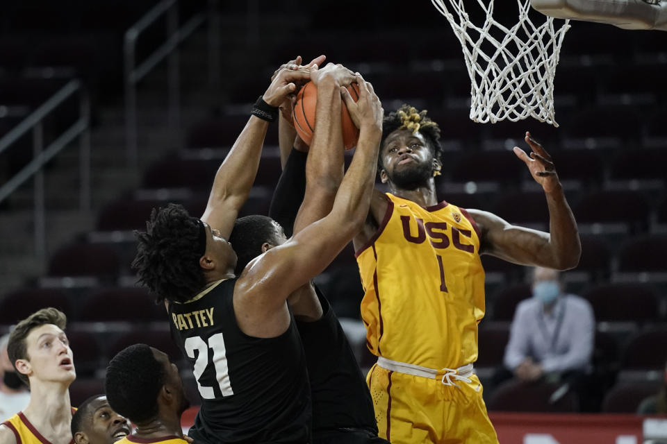 Southern California's Chevez Goodwin, right, fights for a rebound with Colorado's Evan Battey, left, and Jeriah Horne during the second half of an NCAA college basketball game Thursday, Dec. 31, 2020, in Los Angeles. Colorado won 72-62. (AP Photo/Jae C. Hong)