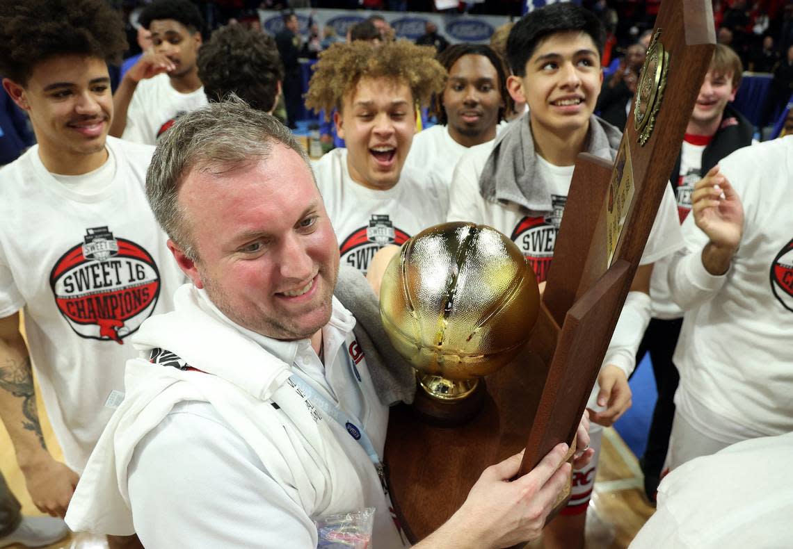 Clark County head coach Josh Cook holds the trophy after the Cardinals won the state championship in Rupp Arena last March.
