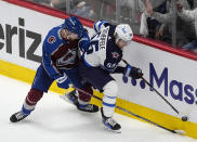 Winnipeg Jets center Mark Scheifele, right, tries to control the puck next to Colorado Avalanche defenseman Devon Toews during the first period of Game 3 of an NHL hockey Stanley Cup first-round playoff series Friday, April 26, 2024, in Denver. (AP Photo/David Zalubowski)