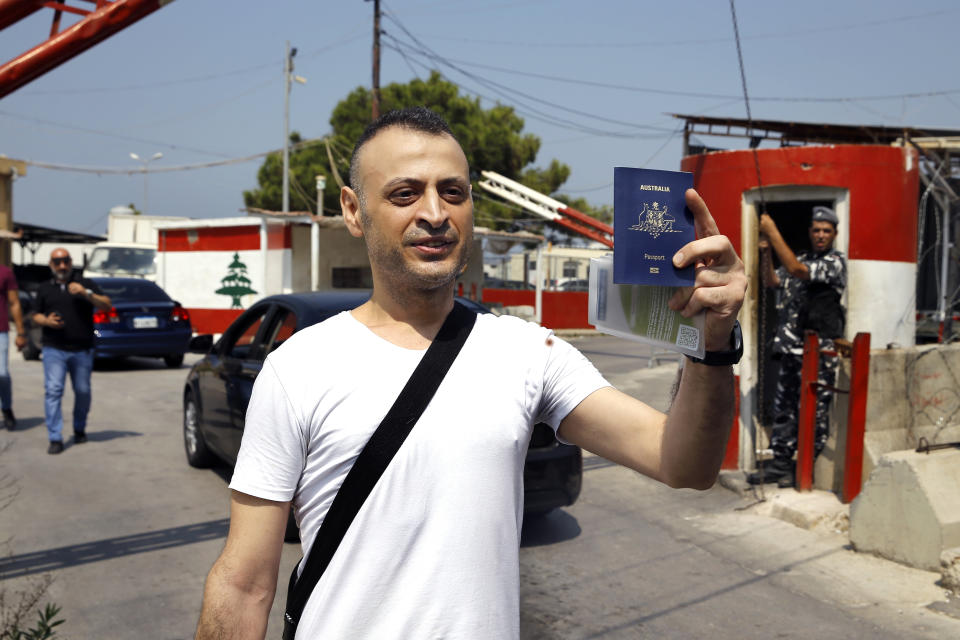 Australian-Lebanese dual citizen Amer Khayyat stands as he holds his Australian passport, after his release from prison in Roumieh, east of Beirut, Lebanon, Friday, Sept. 20, 2019. Lebanese authorities have released the Lebanese -Australian who had been detained in Lebanon for more than two years after he was found innocent in an alleged plot to bring down a passenger plane bound for the United Arab Emirates from Sydney. (AP Photo/Bilal Hussein)