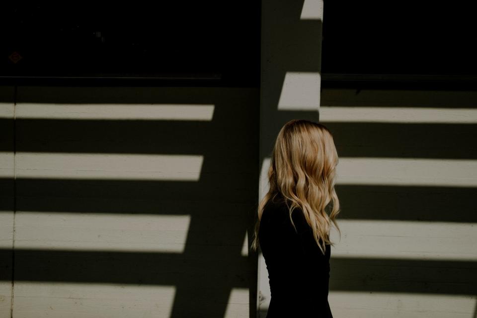 A photo of a woman from the side with her hair blocking her face