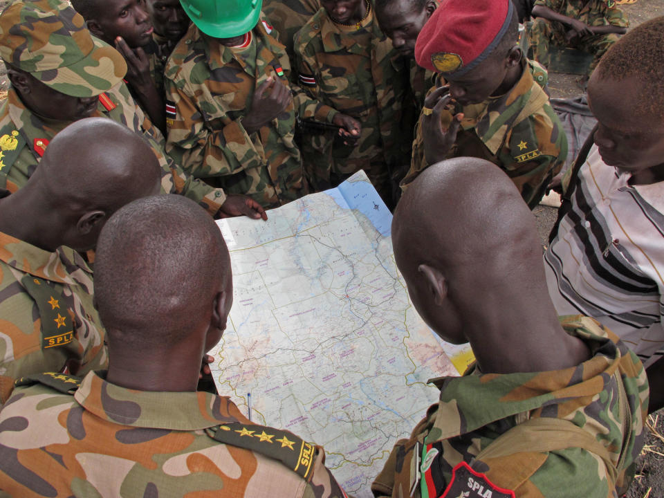 Soldiers from the Sudan People's Liberation Army (SPLA) examine a map at the frontline position in Pana Kuach, Unity State, South Sudan, Friday May 11 2012. In late April, tensions between Sudan and South Sudan erupted into conflict along their poorly defined border. Thousands of SPLA forces have been deployed to Unity State where the two armies are at a tense stalemate around the state's expansive oil fields. Fighting between the armies lulled in early May after the U.N. Security Council ordered the countries to resume negotiations. (AP Photo/Pete Muller)
