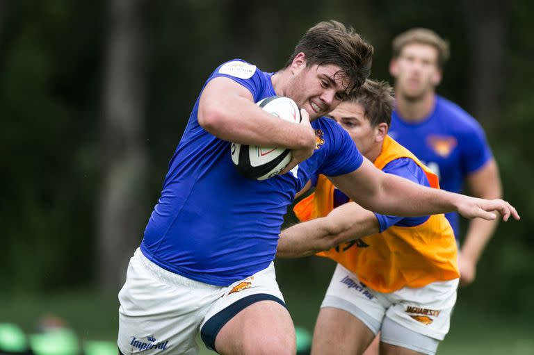 Martín Vaca trata de escapar de un tackle de Sebastián Cancelliere, en una práctica.