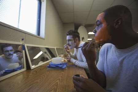 Inmates Tarifa Henson (R) and William Dillon apply make-up on their faces before the workshop "Commedia Dell'Arte", part of the The Actors' Gang Prison Project program at the California Rehabilitation Center in Norco, California in this September 30, 2014 file photo. REUTERS/Mario Anzuoni/Files