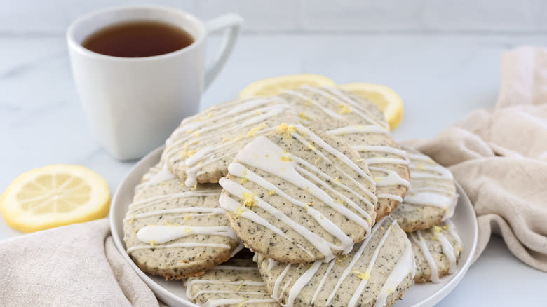 Plate of lemon-glazed Earl Grey cookies with a cup of tea behind it