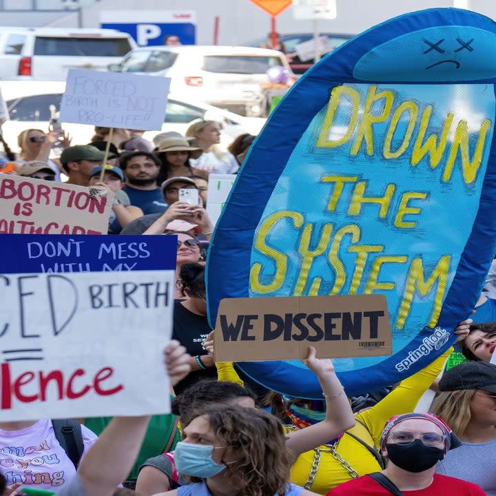 close up of people walking the street with protest signs