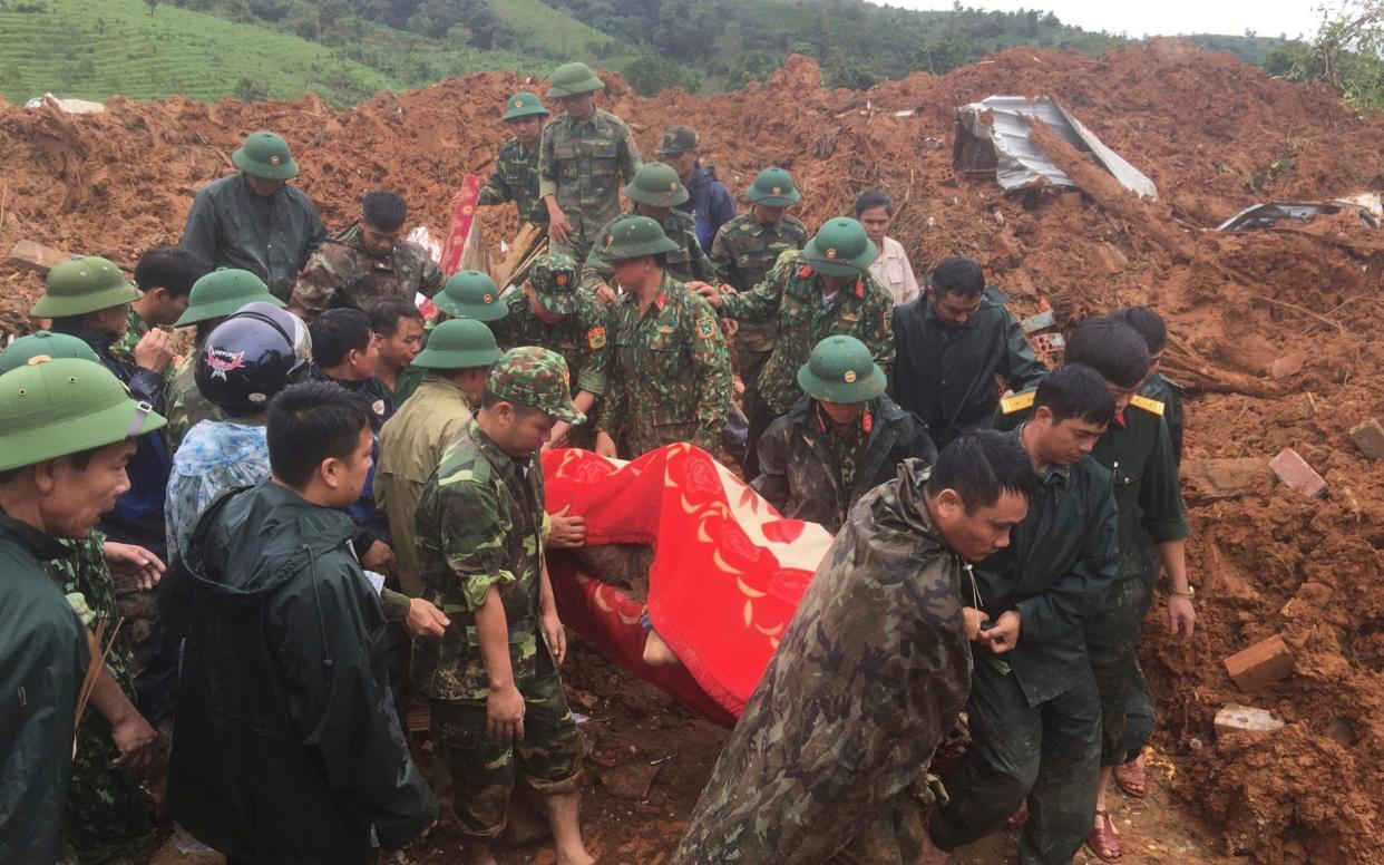 Army officers carry a body recovered from a landslide in Quang Tri province, - VNA