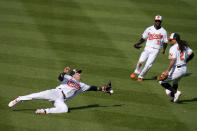 Baltimore Orioles left fielder Ryan Mountcastle, left, attempts a diving catch on a ball hit by Boston Red Sox's Christian Vazquez during the sixth inning of a baseball game, Thursday, April 8, 2021, on Opening Day in Baltimore. Orioles Cedric Mullins (31) and Freddy Galvis (2) look on. (AP Photo/Julio Cortez)